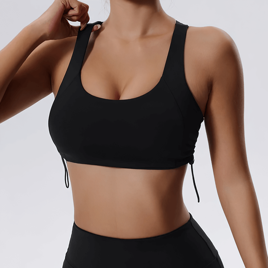 Woman wearing a black sexy adjustable sports bra for fitness and yoga with breathable back design, perfect for high-impact workouts.